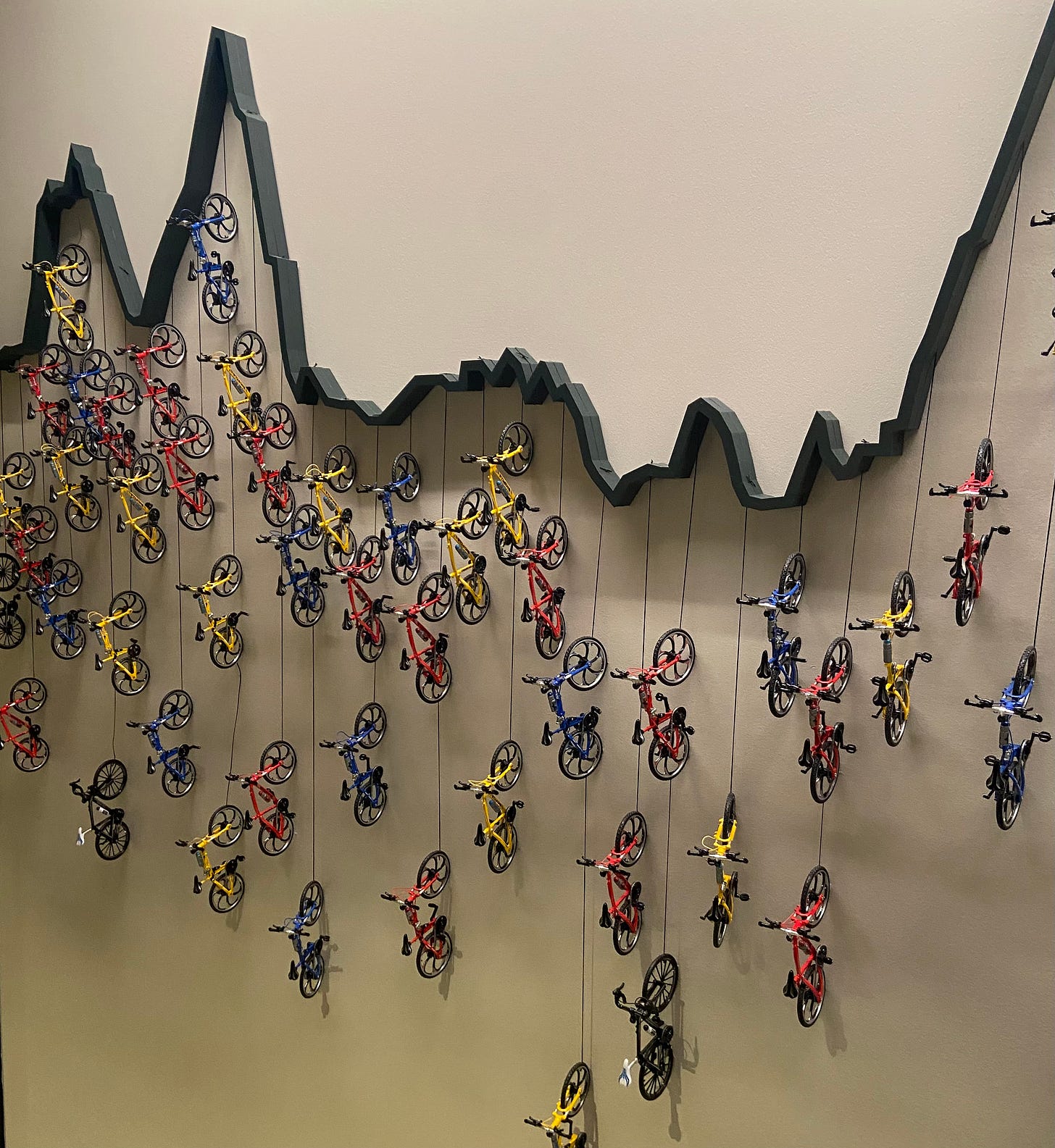 tiny bikes suspended on a wall