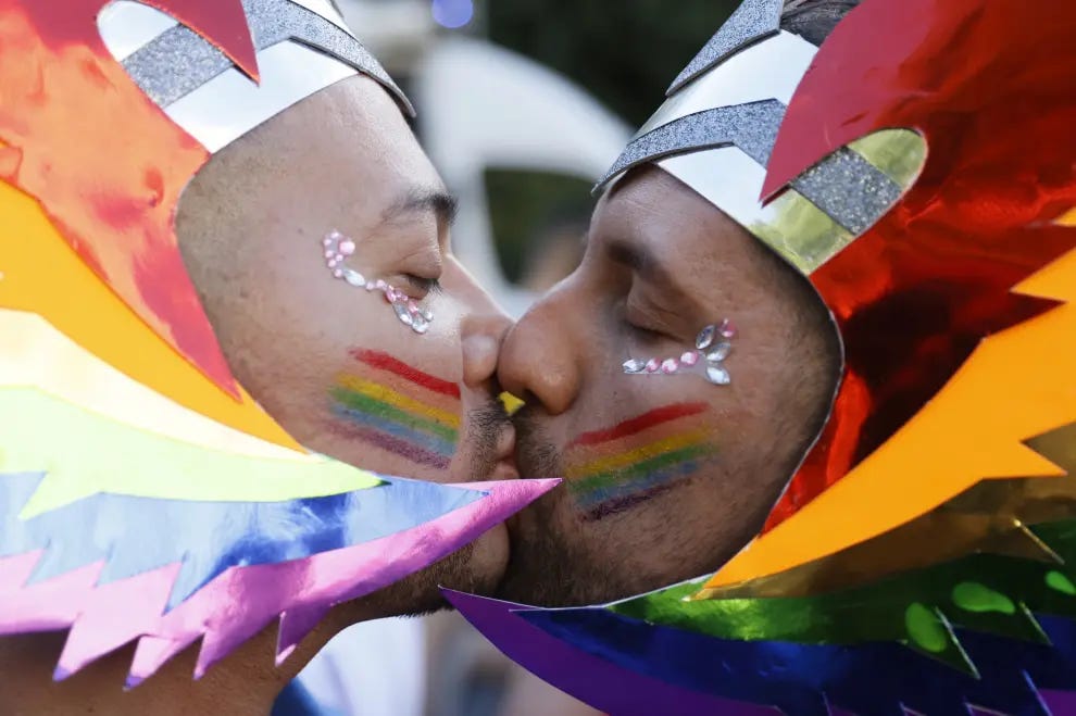 Dos participantes en el desfile del Orgullo se besan. Dos participantes en el desfile del Orgullo se besan.