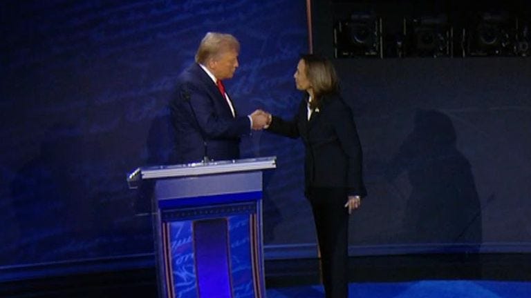 The Democratic presidential nominee approaches Donald Trump on his side of  the stage to shake hands before the debate begins.