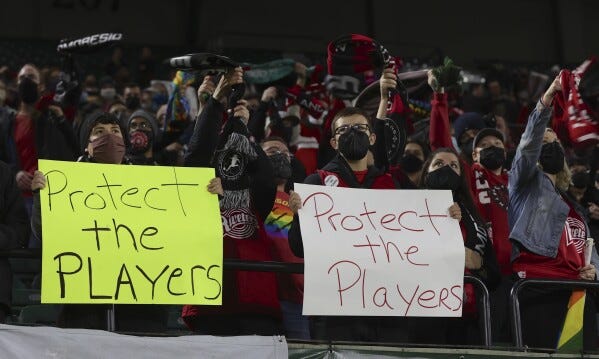 Portland Thorns fans hold signs during the first half of the team's NWSL soccer match against the Houston Dash in Portland, Ore., Oct. 6, 2021. (AP Photo/Steve Dipaola, File)