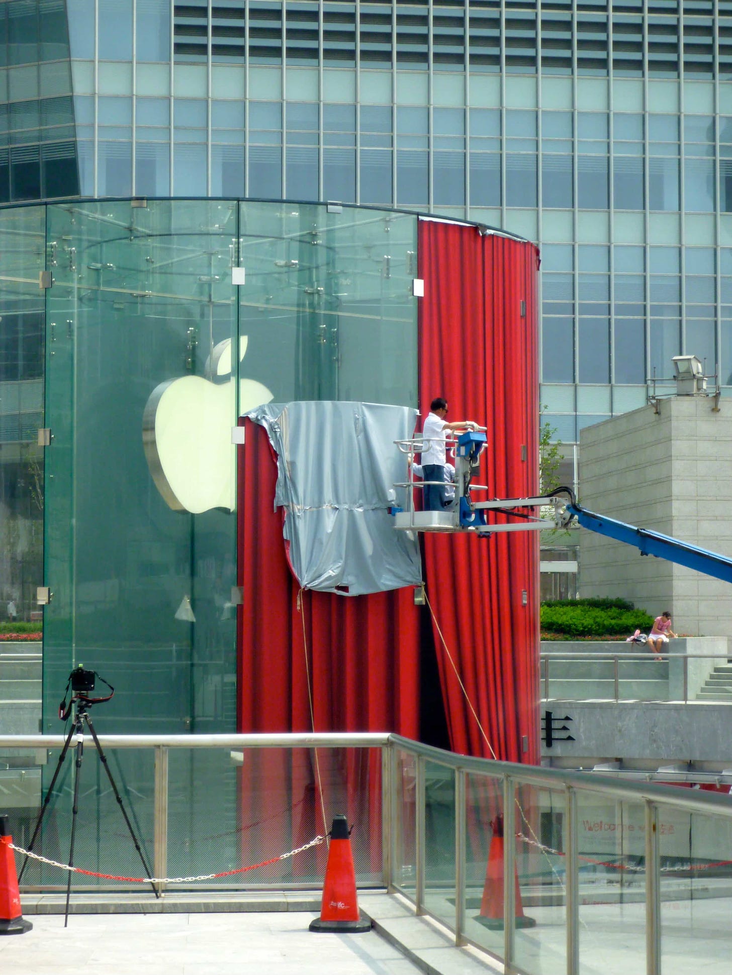 Apple Pudong close-up and being unwrapped shortly before opening in 2010. The vinyl covering the store has the appearance of a red stage curtain.