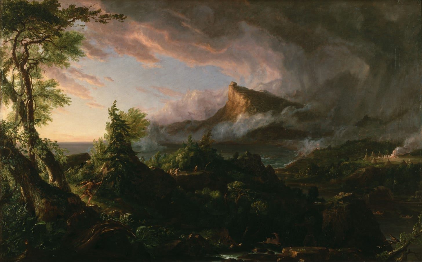 An oil painting entitled "The Course of Empire, The Commencement of Empire". It depicts a vast landscape at dawn. There is a fog-covered mountain in the background and an ocean is barely visible through the trees. Small humans wielding spears and wearing loincloths run through the woods. A few and small tents are barely visible in the right mid ground.