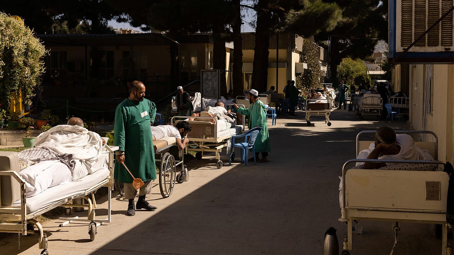 This picture shows patients sunbathing at the Red Cross rehabilitation center in Kabul, Afghanistan October 15, 2021. Picture taken October 15, 2021. There are doctors standing to the sides of the hospital beds with some beds in the shade and others in the sun.