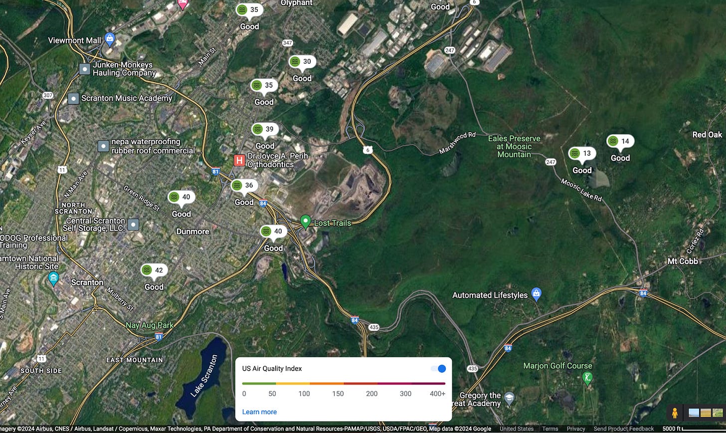 Google maps showing satellite view of Scranton, Dunmore, and Throop, on the west side of the image, including the Keystone Landfill at the center with The Casey Highway / Route 6 rounding about the garbage dump on the east side, and the forests and highways to Mt Cobb on the east side of the map. The map has air quality monitors ranging in the 30s AQI in the valley and in the teens to the east toward the Poconos.