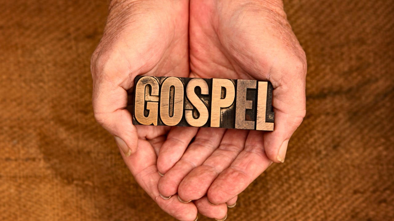A person holding the word "Gospel" in their hands.