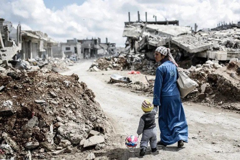 Woman and Child walking among destroyed buildings during the Arab Spring.