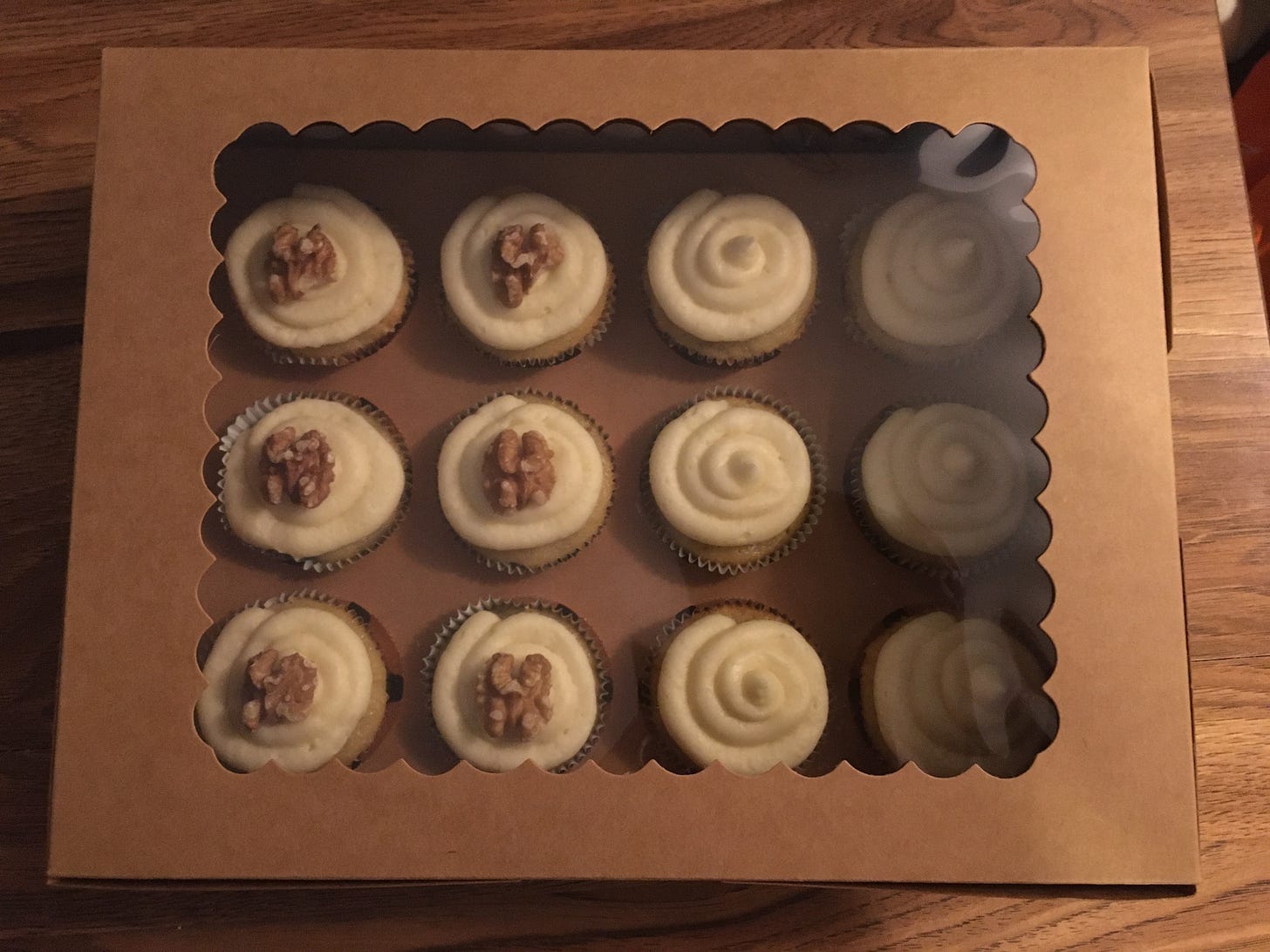Picture of twelve banana cupcakes in craft paper box.