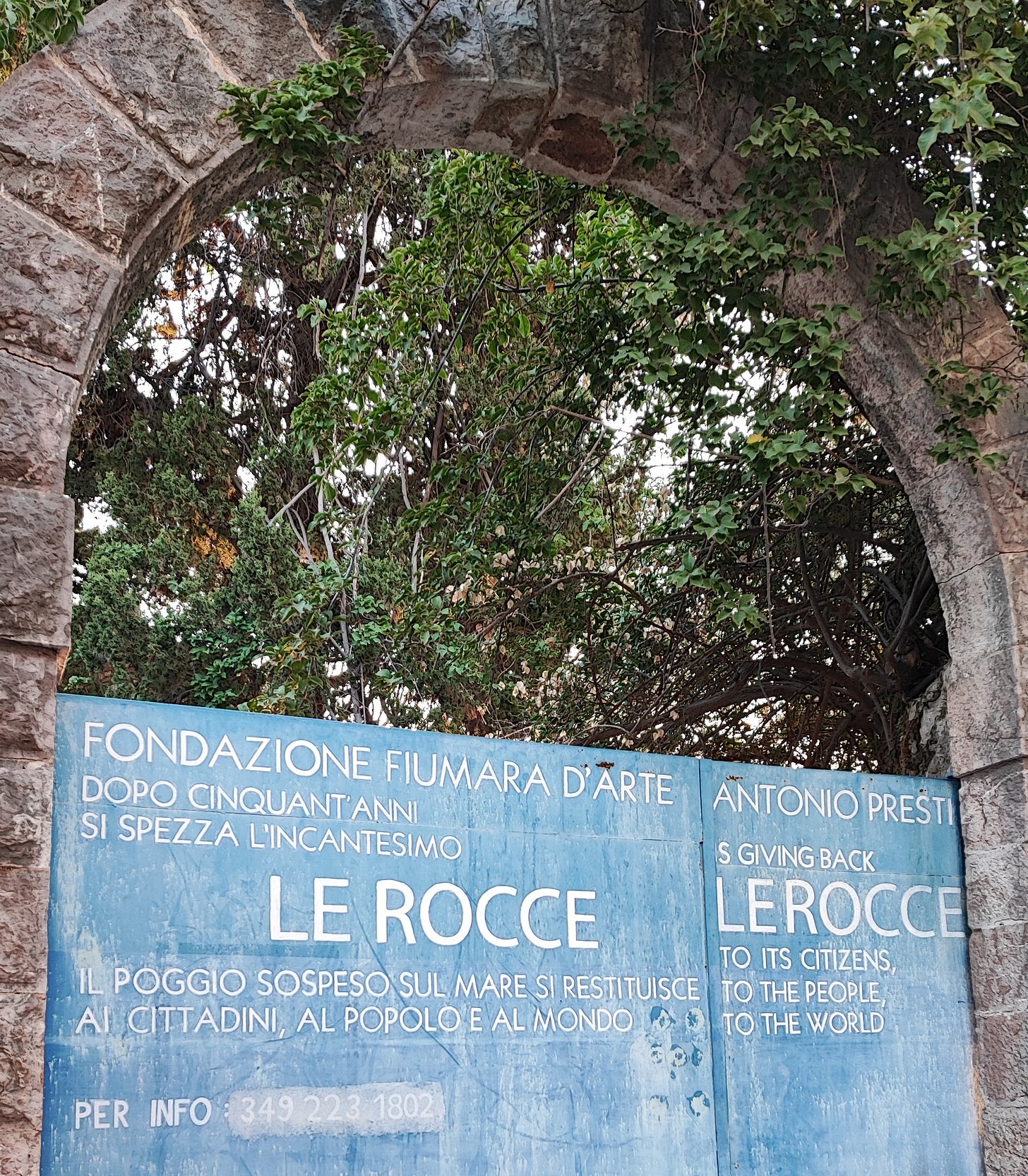 arco di pietra con cancello azzurro del villaggio Le Rocce