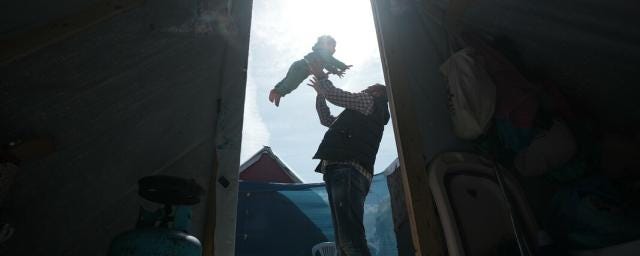 Fedaa plays with his 3-year-daughter in the middle of his tent in Rafah which he took refuge after losing his house and factory.