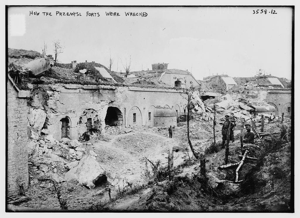 Black and white picture showing a heavily damaged fort with a couple of Russian soldiers looking on.