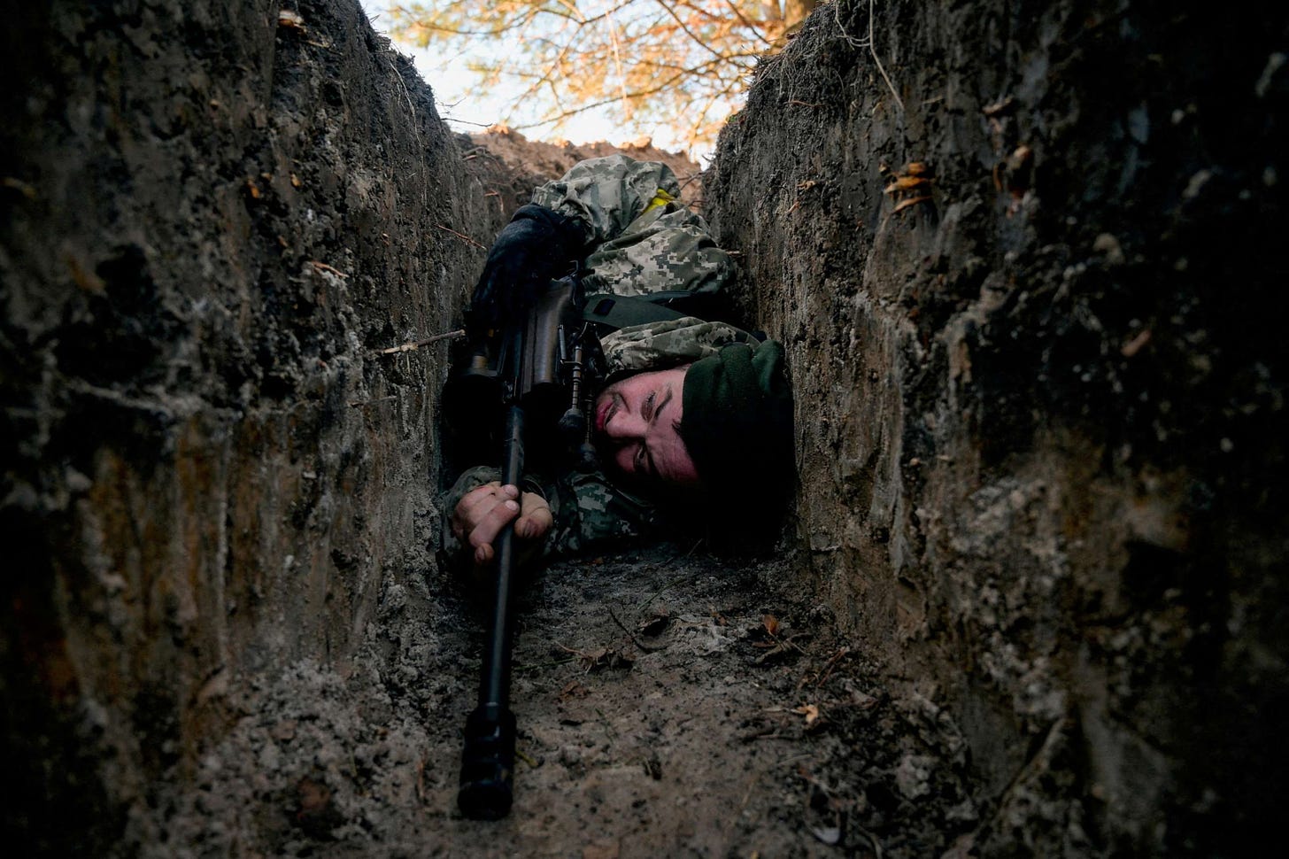 FILE PHOTO: A Ukrainian soldier hides from a helicopter air strike amid Russia's invasion of Ukraine, near Demydiv, Ukraine, March 10, 2022.