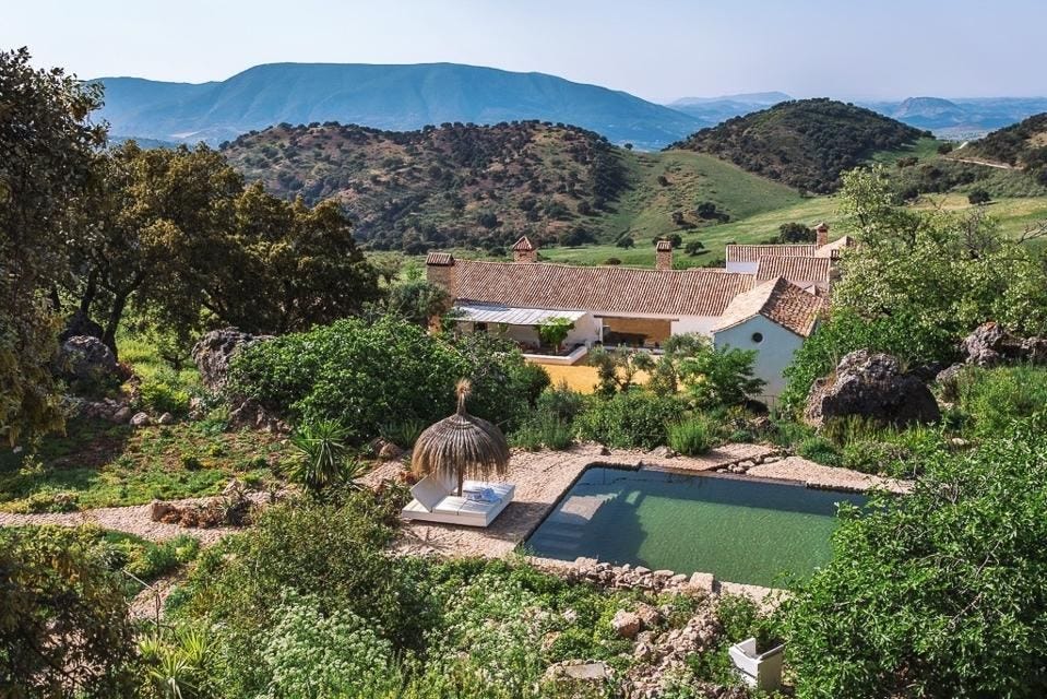 The pool and the main farmhouse are tucked into the hills of Andalusia at Finca La Donaira