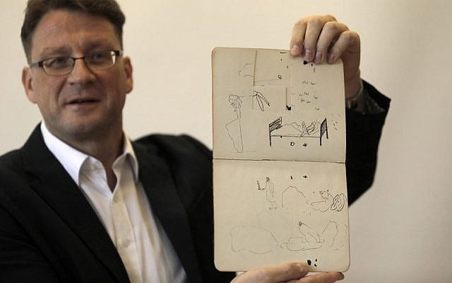 National Library archival expert and Humanities Collection Curator Stefan Litt shows drawings by novelist Franz Kafka, during a press conference in the National Library of Israel in Jerusalem, on August 7, 2019. Hundreds of letters, manuscripts, journals, notebooks, sketches and more - handwritten by Brod and Kafka - have been transferred to the National Library of Israel, following orders by Israeli and Swiss courts to open vaults in Zurich, which had stored the materials for decades. These materials, part of Max Brod's literary estate, have now been returned to Israel and have arrived at the National Library in Jerusalem, in accordance with Brod's wishes. (Menahem Kahana / AFP)