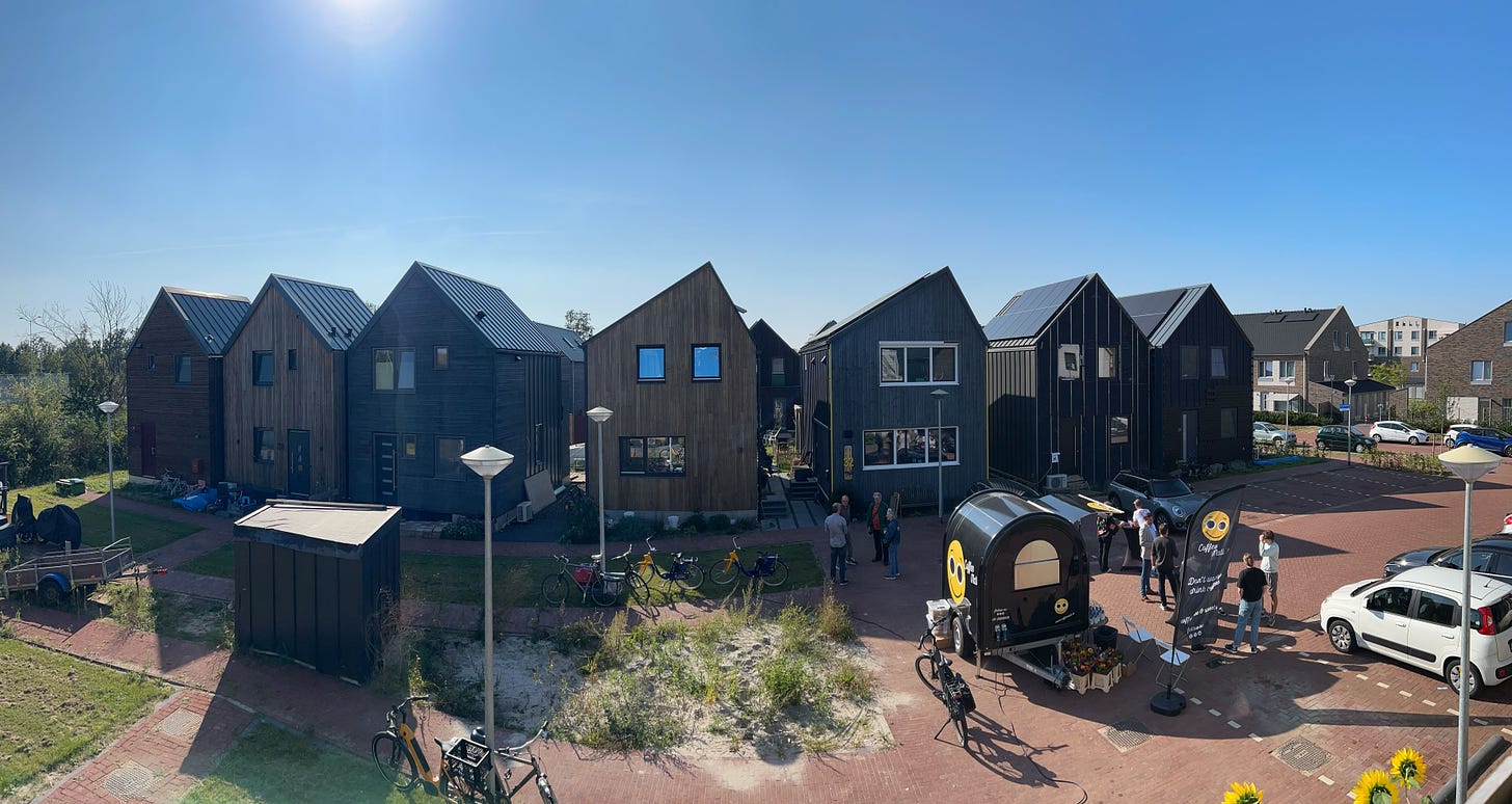 Image of 7 WikiHouses in a row on a sunny day.