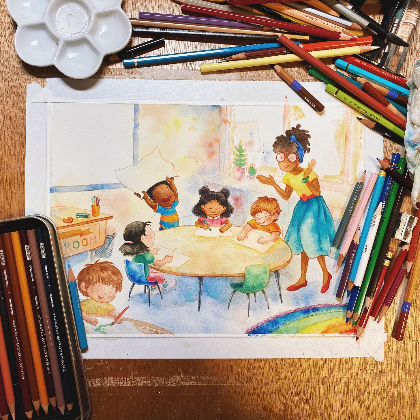 A photo of an illustration in progress surrounded by pencils and other art supplies