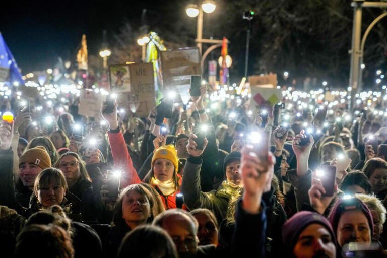 People hold up their phones as they protest the far-right Alternative for Germany, or AfD party, and right-wing extremism in front of the Brandenburg Gate in Berlin on Saturday. ((Ebrahim Noroozi / Associated Press))