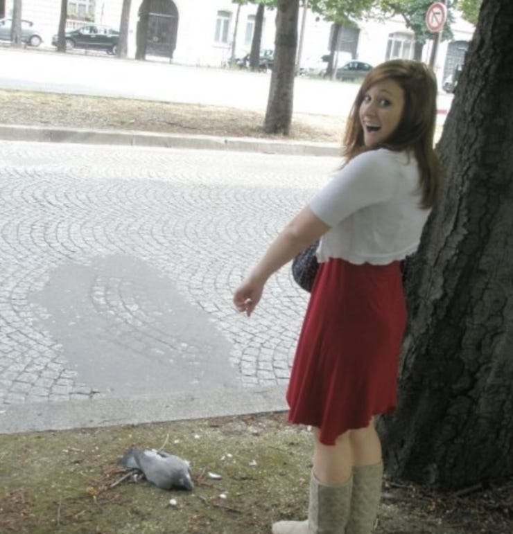 Me pointing at a dead dove in Paris to illustrate the beauty of the city