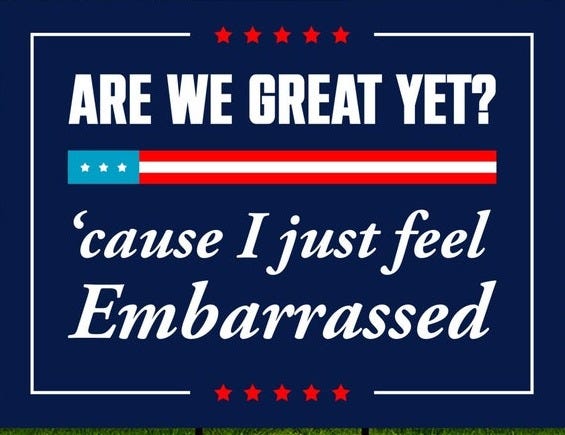 May include: A blue and red yard sign with white text that reads 'Are we great yet? 'cause I just feel embarrassed.' The sign has a red and blue American flag design at the top and bottom.