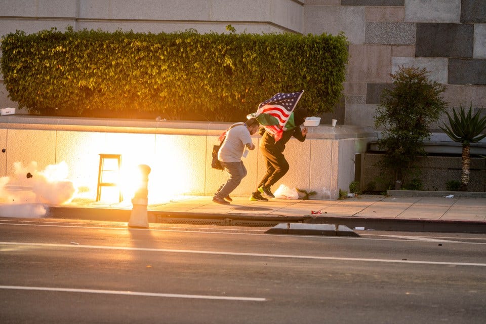 A stinger grenade explodes near protestors during a "No Kings Day" protest in Los Angeles.