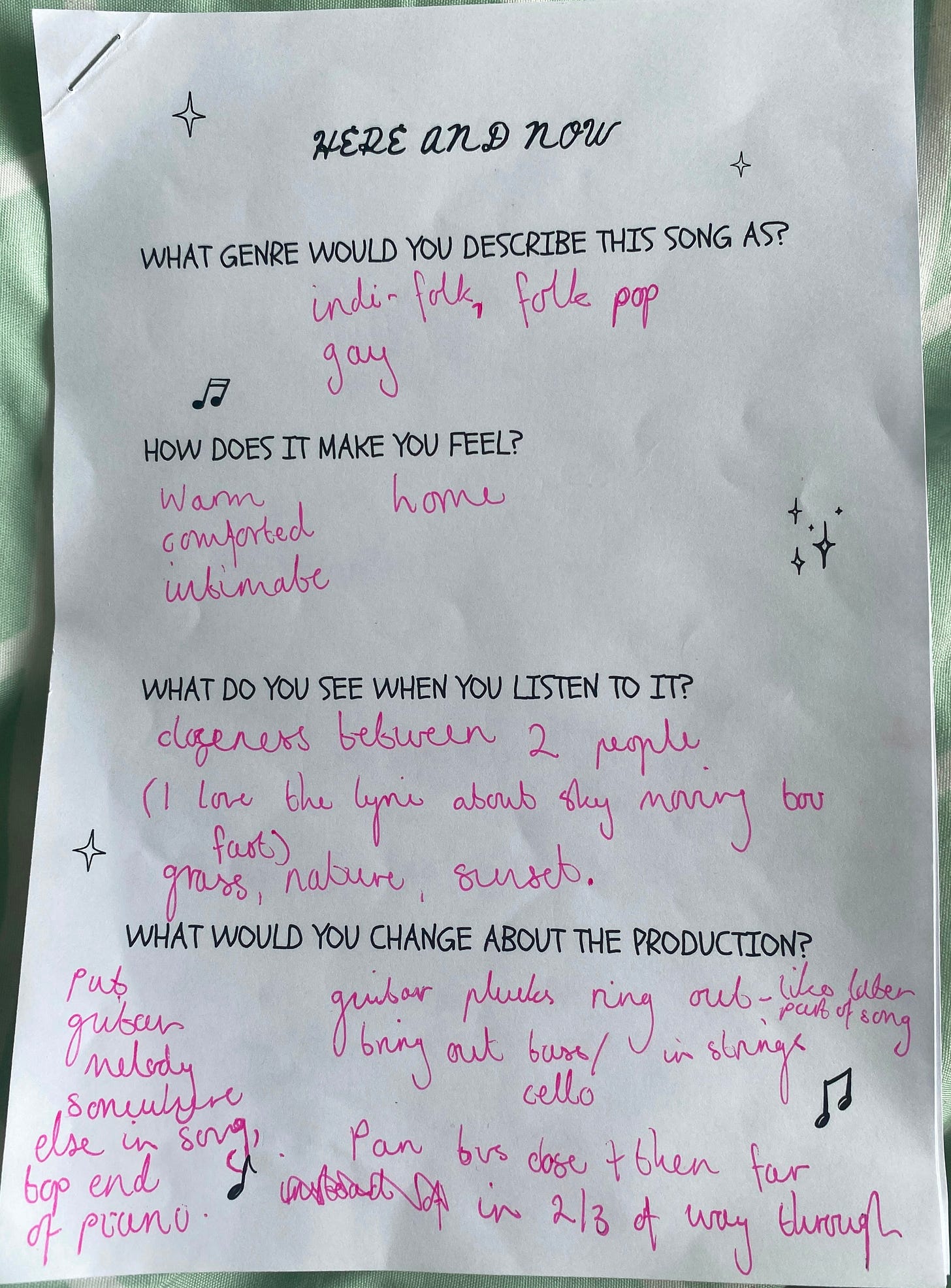 A printed worksheet with questions such as "what genre would you describe this song as?" and "how does this song make you feel?", with answers such as "indie-folk" and "warm and comfortable" written in pink pen.