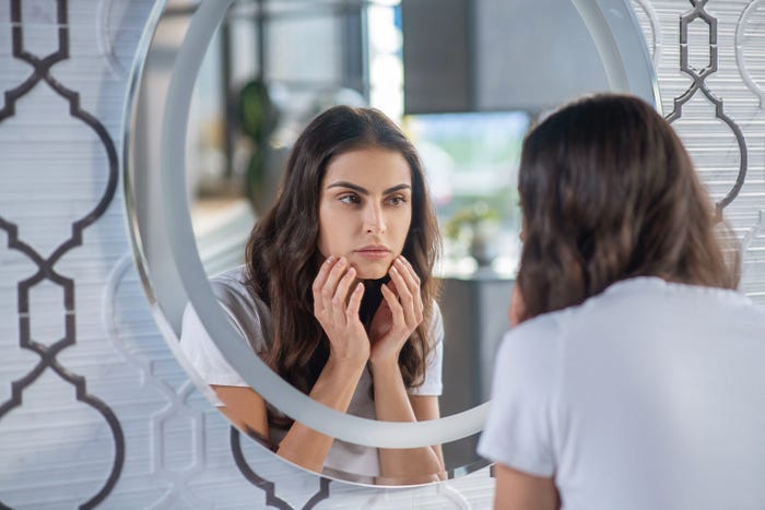 A woman looking at herself in the mirror. A woman looking at herself in the mirror.