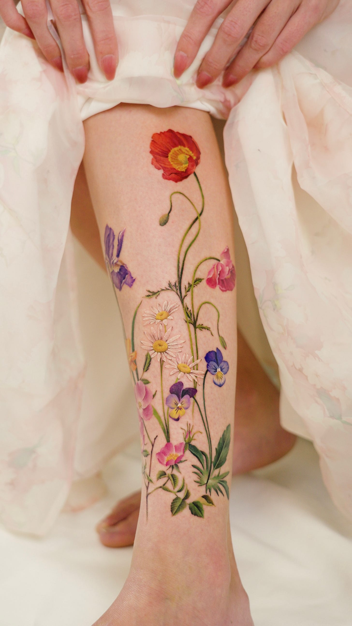 A vibrant floral tattoo on a woman's leg