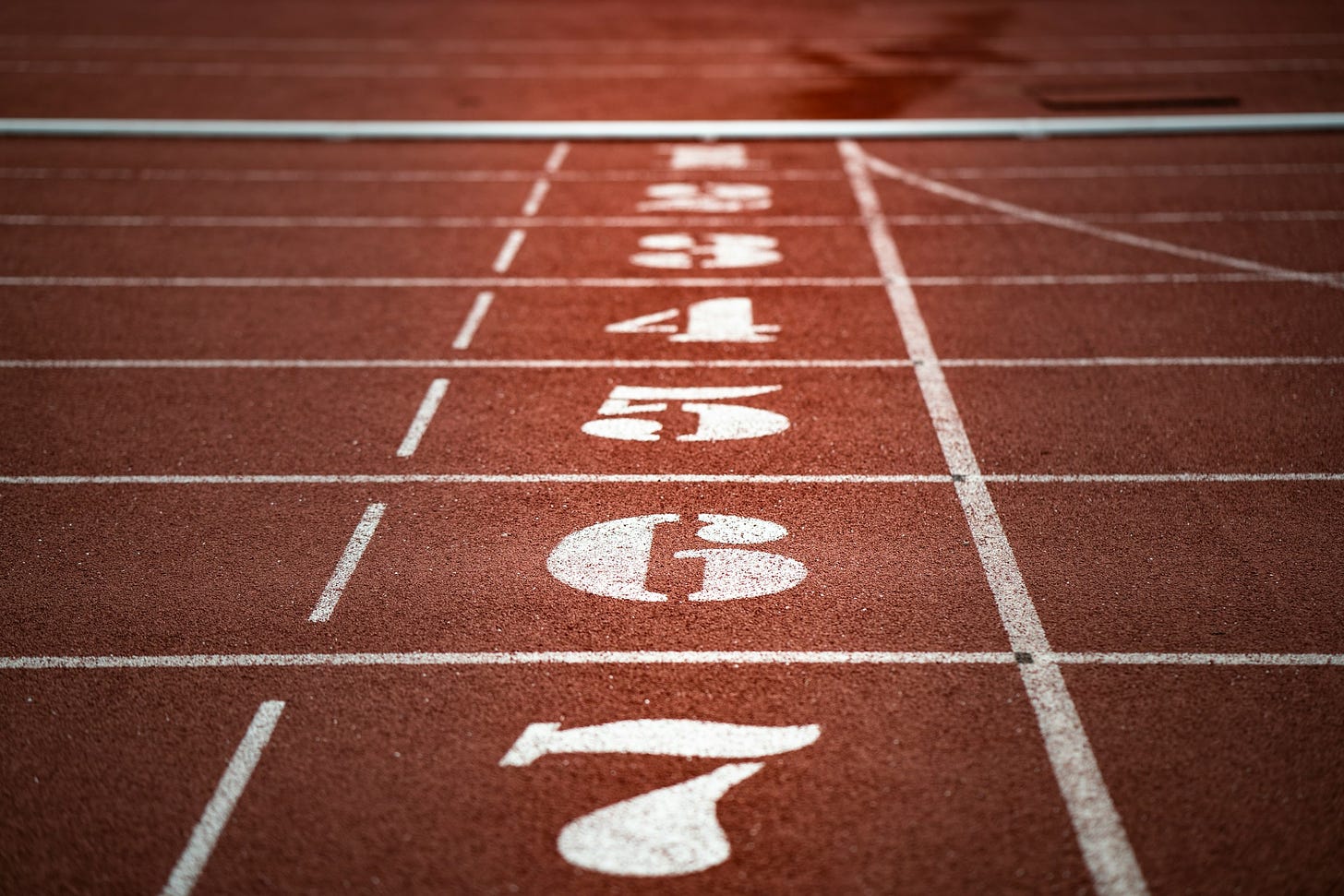 Track starting line with lines in white. The track color is burnt red/brown