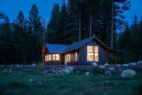 The house at night, with the windows illuminated.