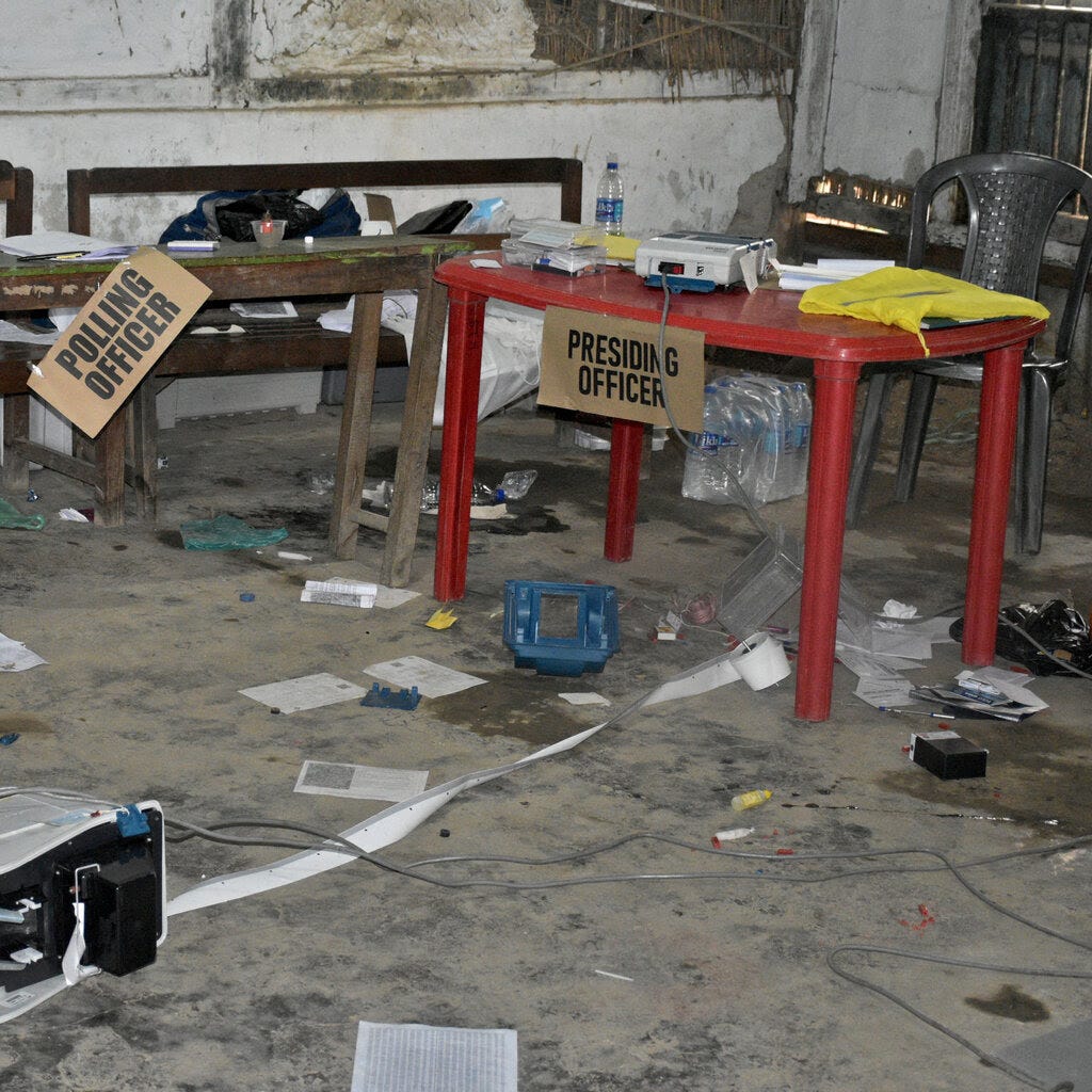 A view of a room with papers and debris of a broken electronic device scattered on the floor. 