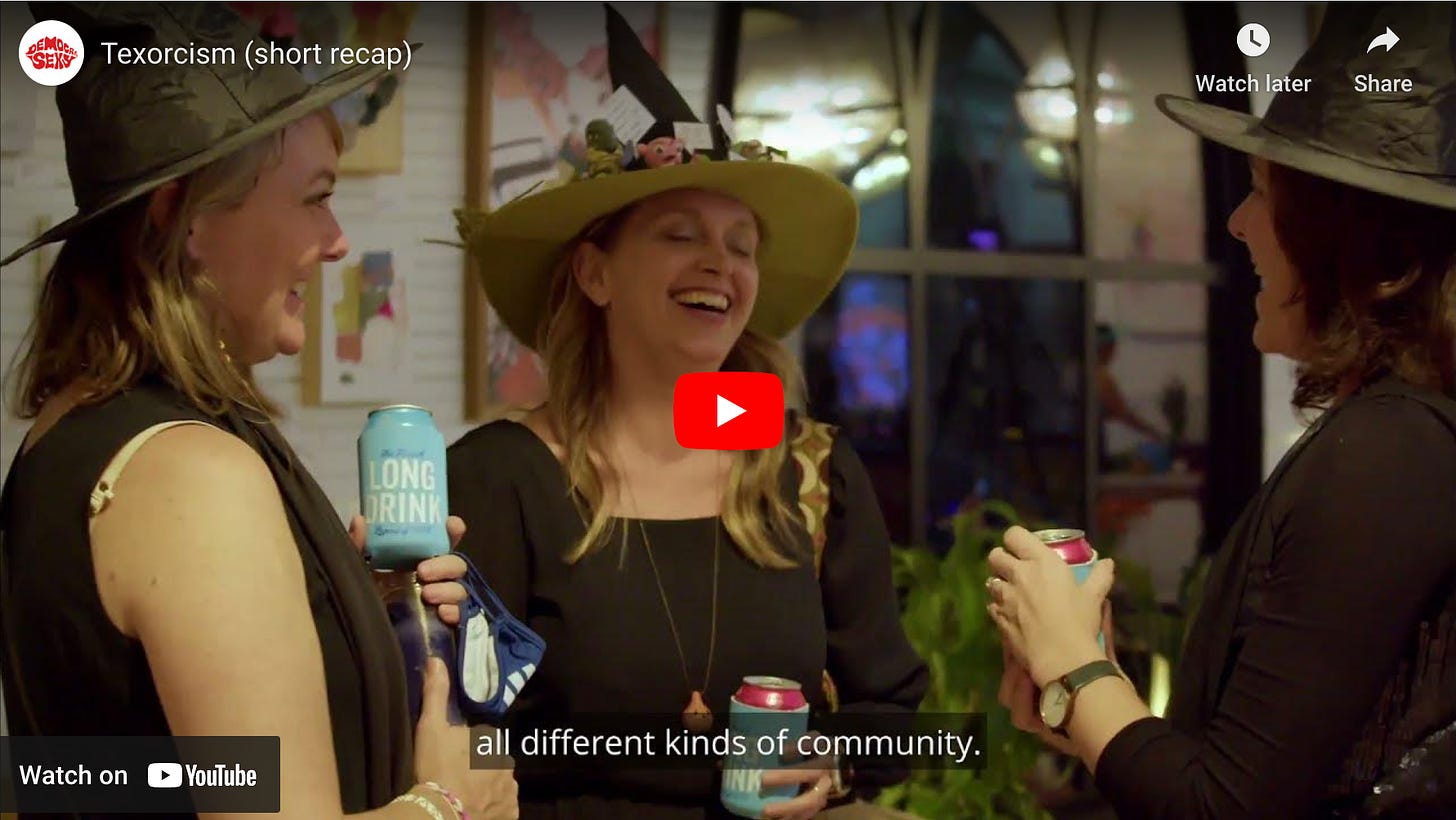 A screenshot from a YouTube video from the first Texorcism where three women in elaborate witches' hats are holding drinks and laughing.