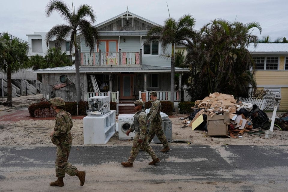 Members of the Florida Army National Guard check for any remaining residents in nearly-deserted Bradenton Beach on Anna Maria Island, Florida