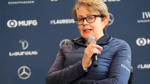 Getty Images Baroness Tanni Grey-Thompson wears black glasses and a blue anorak, and is holding a microphone