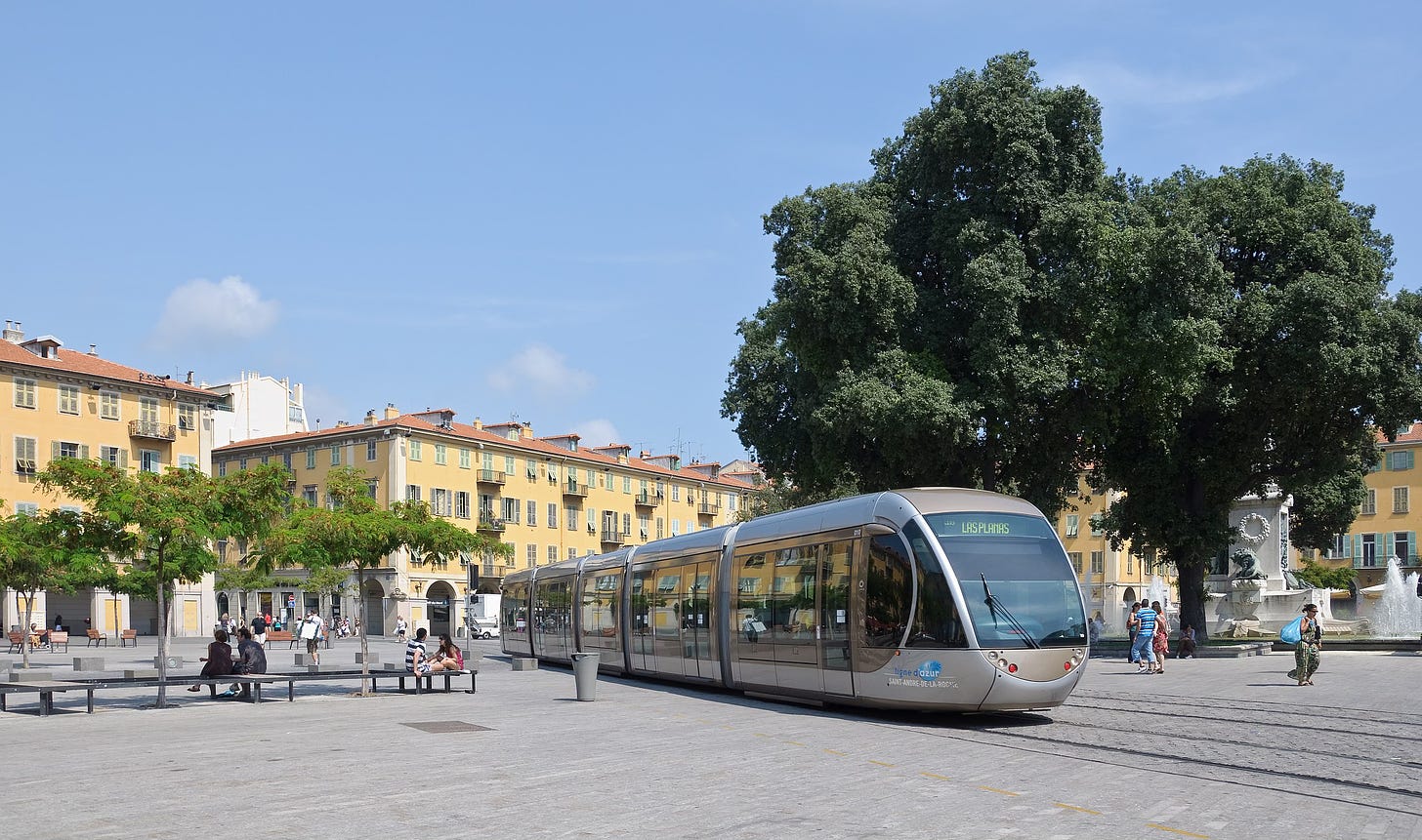 Wheelchair accessible tram passing through city square in Nice, France.