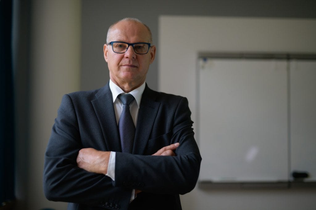 Confident Senior Businessman With Arms Crossed By The Window