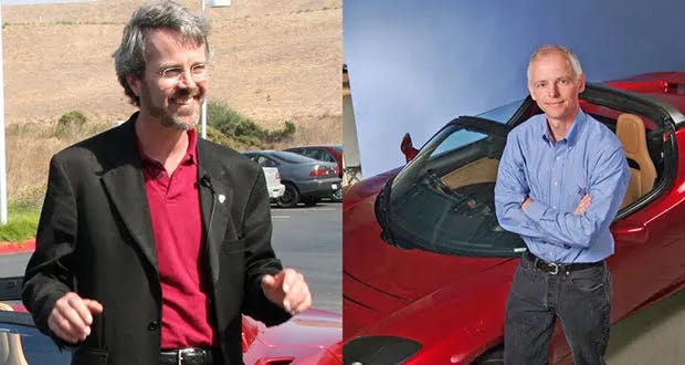 two men standing next to a tesla car