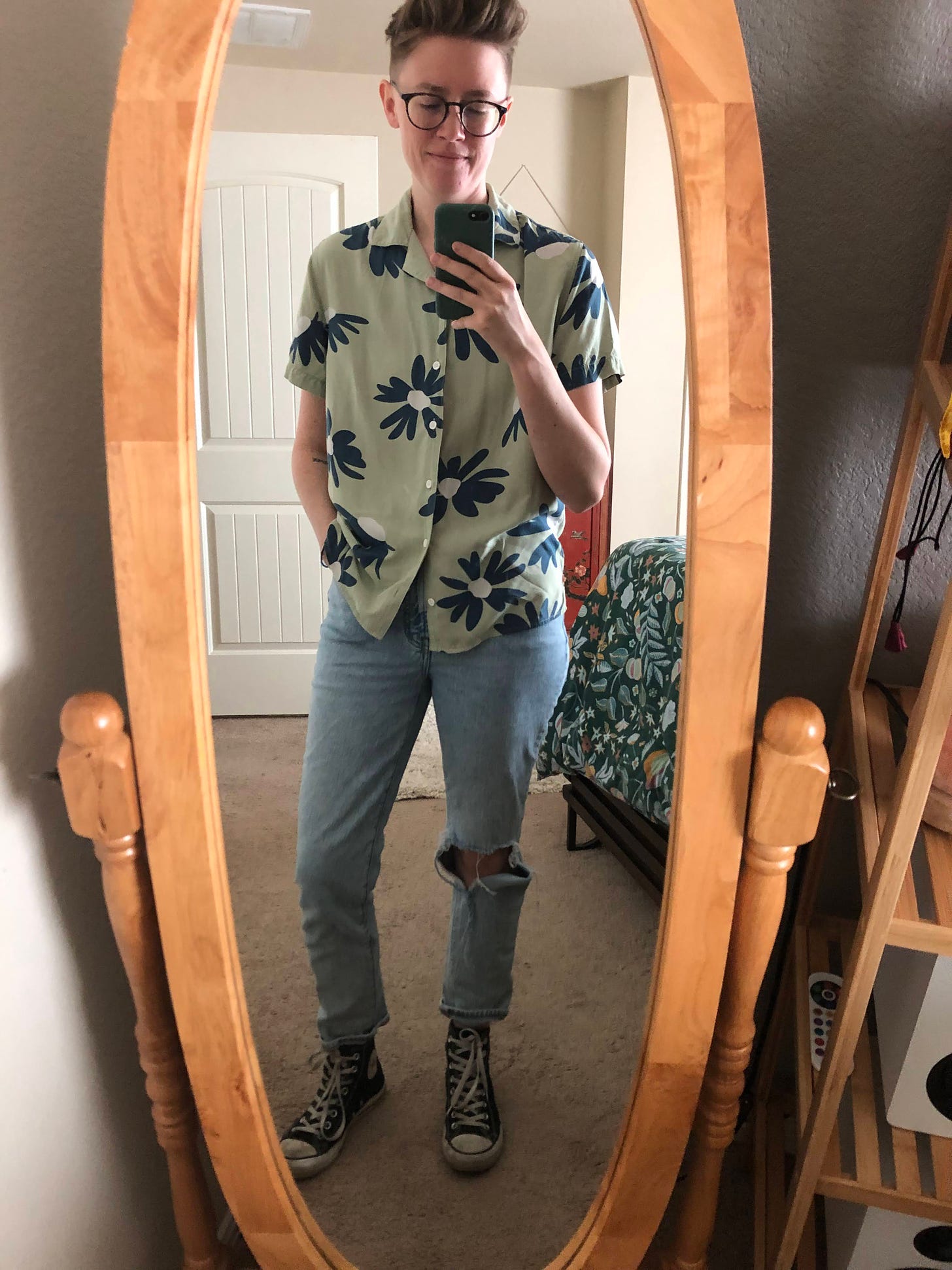 Caley wearing a floral camp shirt and pale denim.