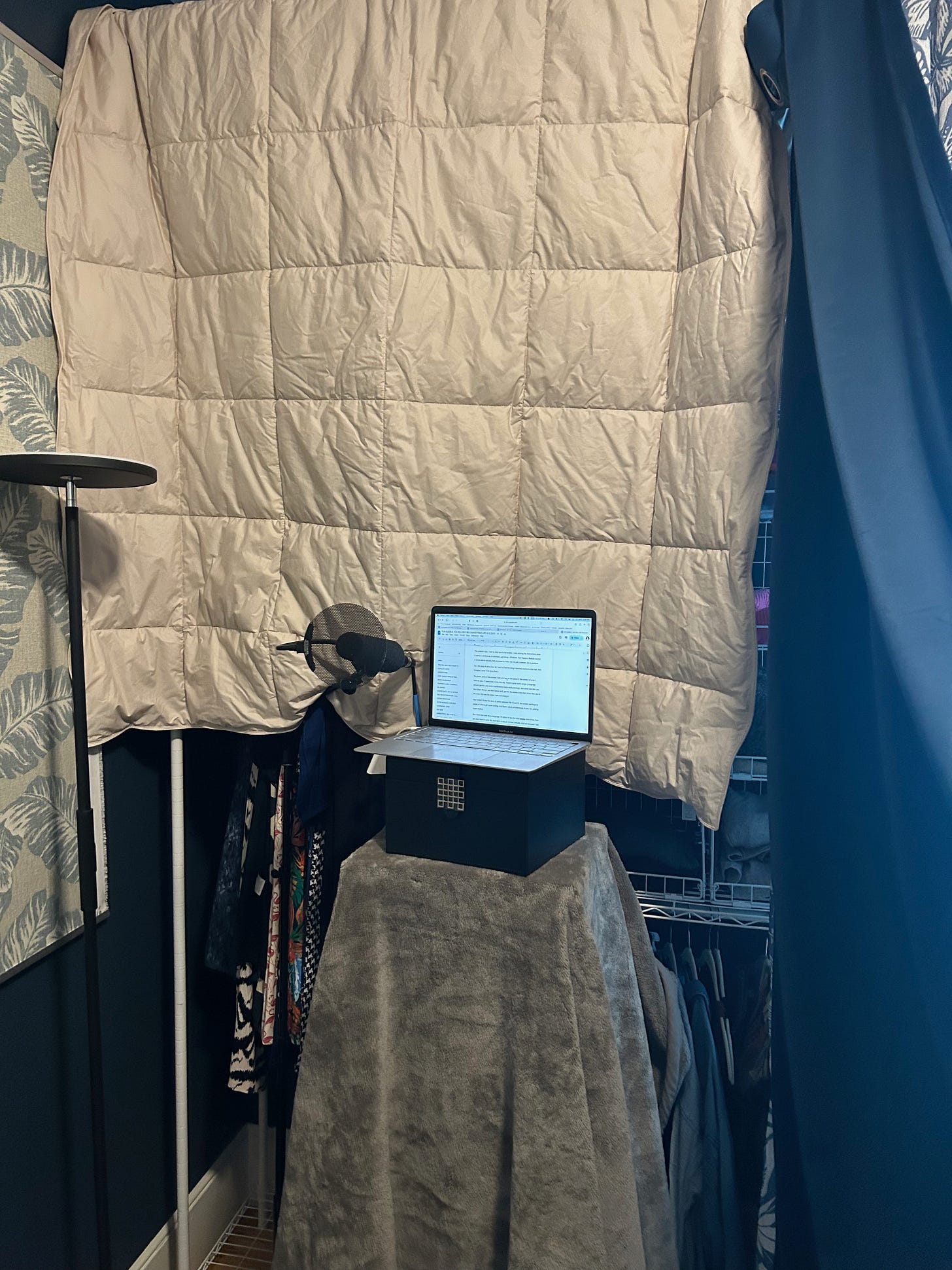 a home recording set up with blankets and curtains.