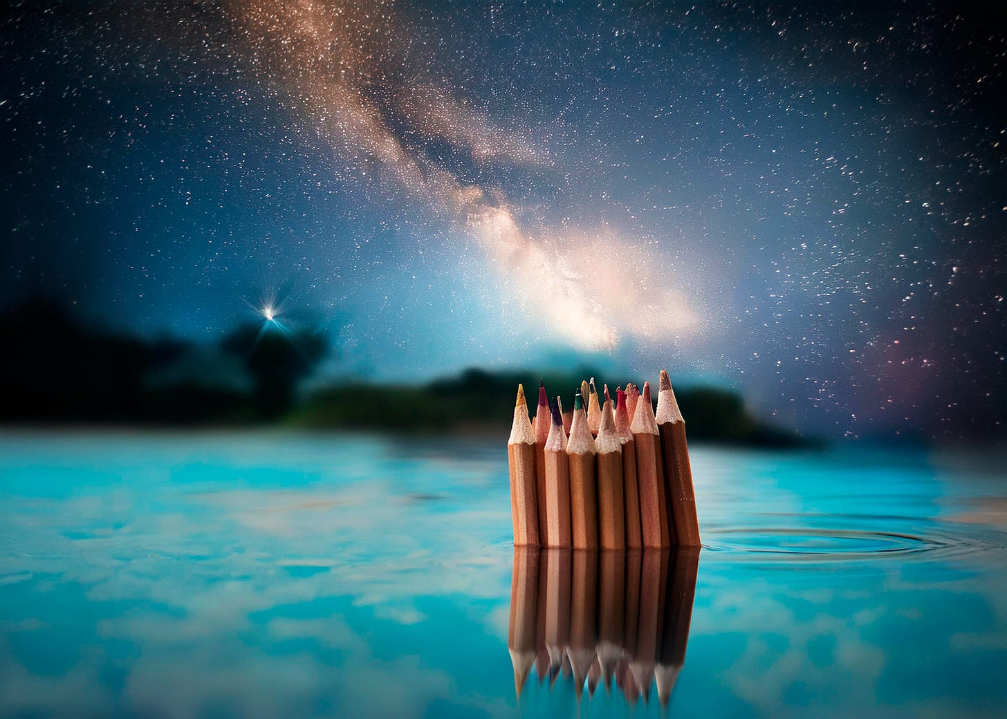 surreal view of artist's pencils in turquoise water with celestial night sky above