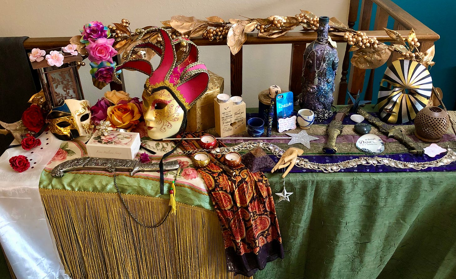 An altar decorated with masks, candles, roses, stars, daggers and twining leaves. On the left, the hues are reds, pinks, golds; on the right are silver, gold, midnight blue and purple.