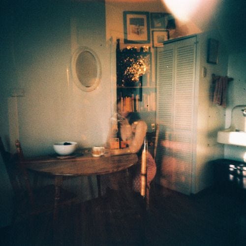 This may contain: a dining room table and chairs in front of an open door with shutters on the side