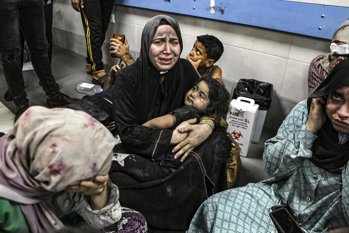 Wounded Palestinians sit in al-Shifa hospital in Gaza City after arriving from al-Ahli hospital on Tuesday. 
