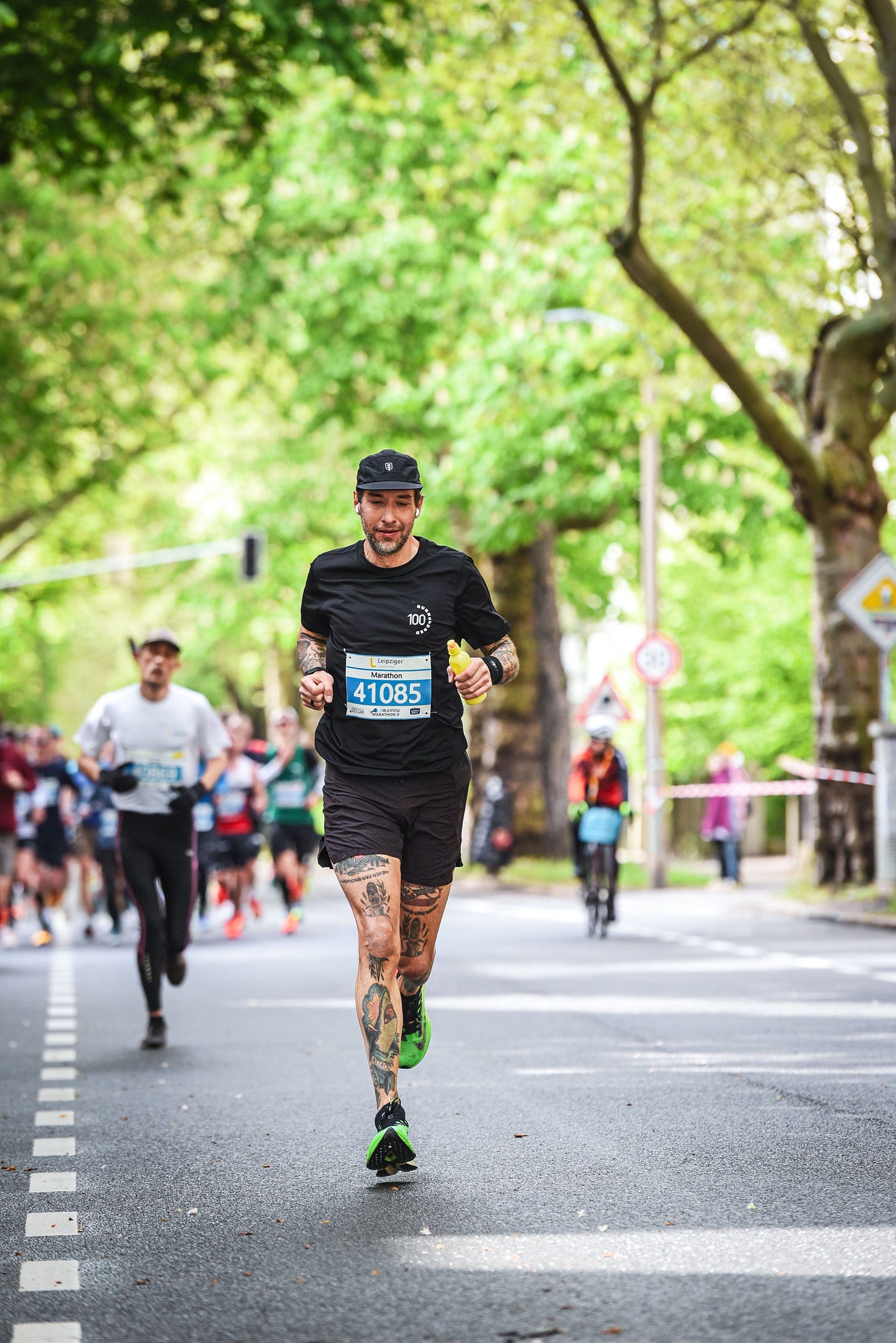 The author running in front of a group of runners with a bottle in his hand