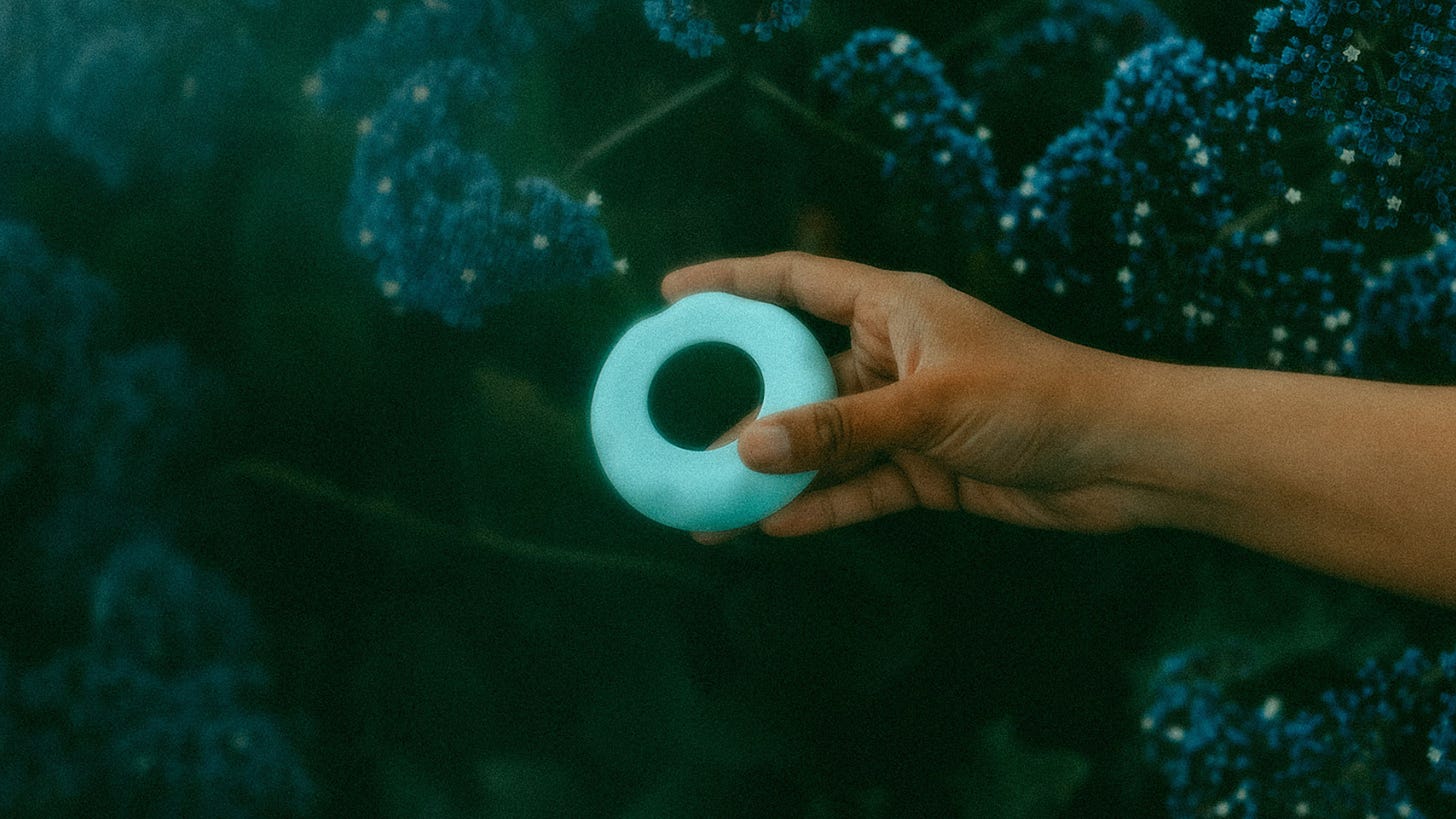 Image description: A blue adaptive dilator ring photographed underwater with coral in the background.