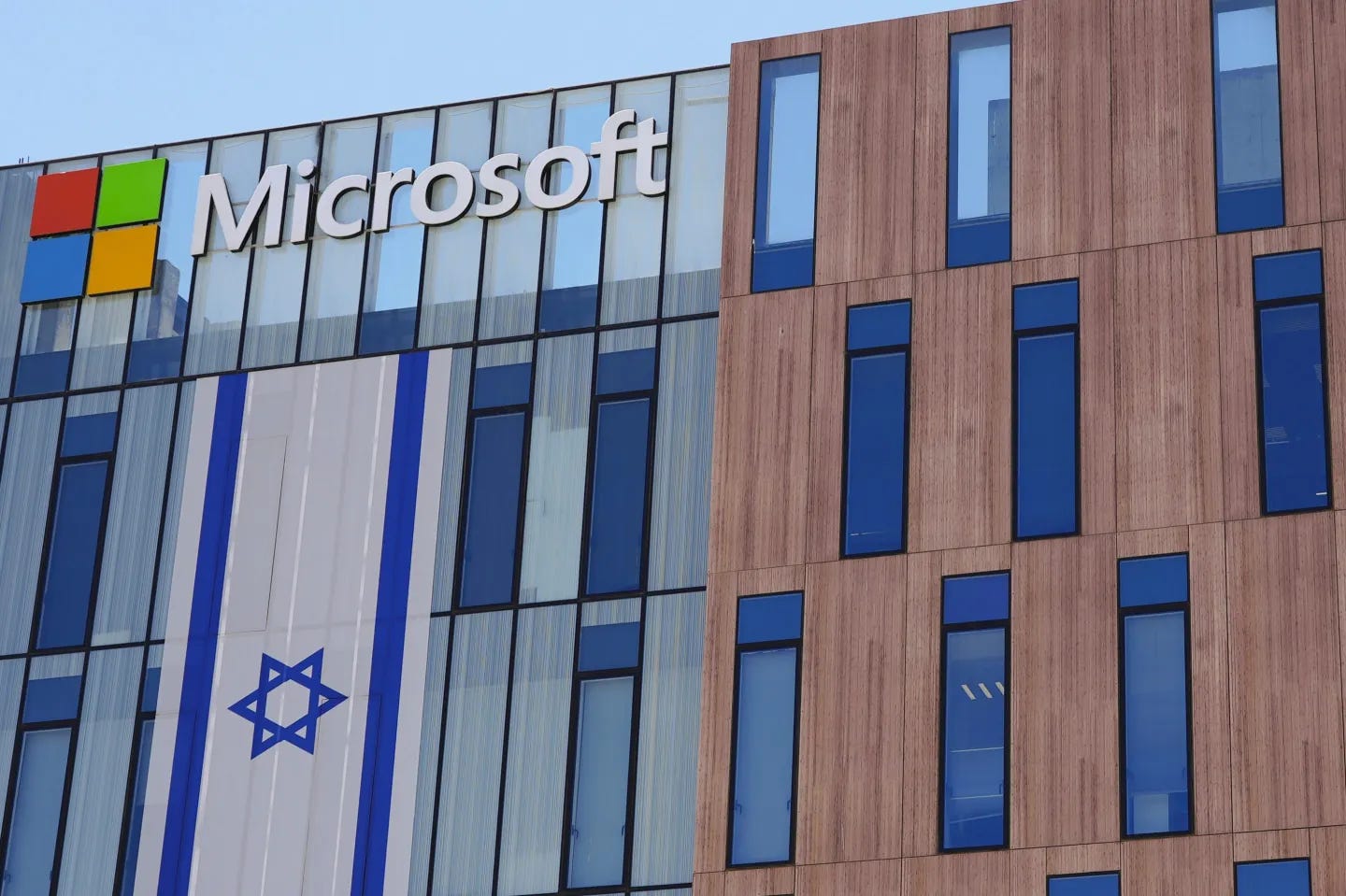 A Microsoft building with a large Israeli flag hanging from the exterior