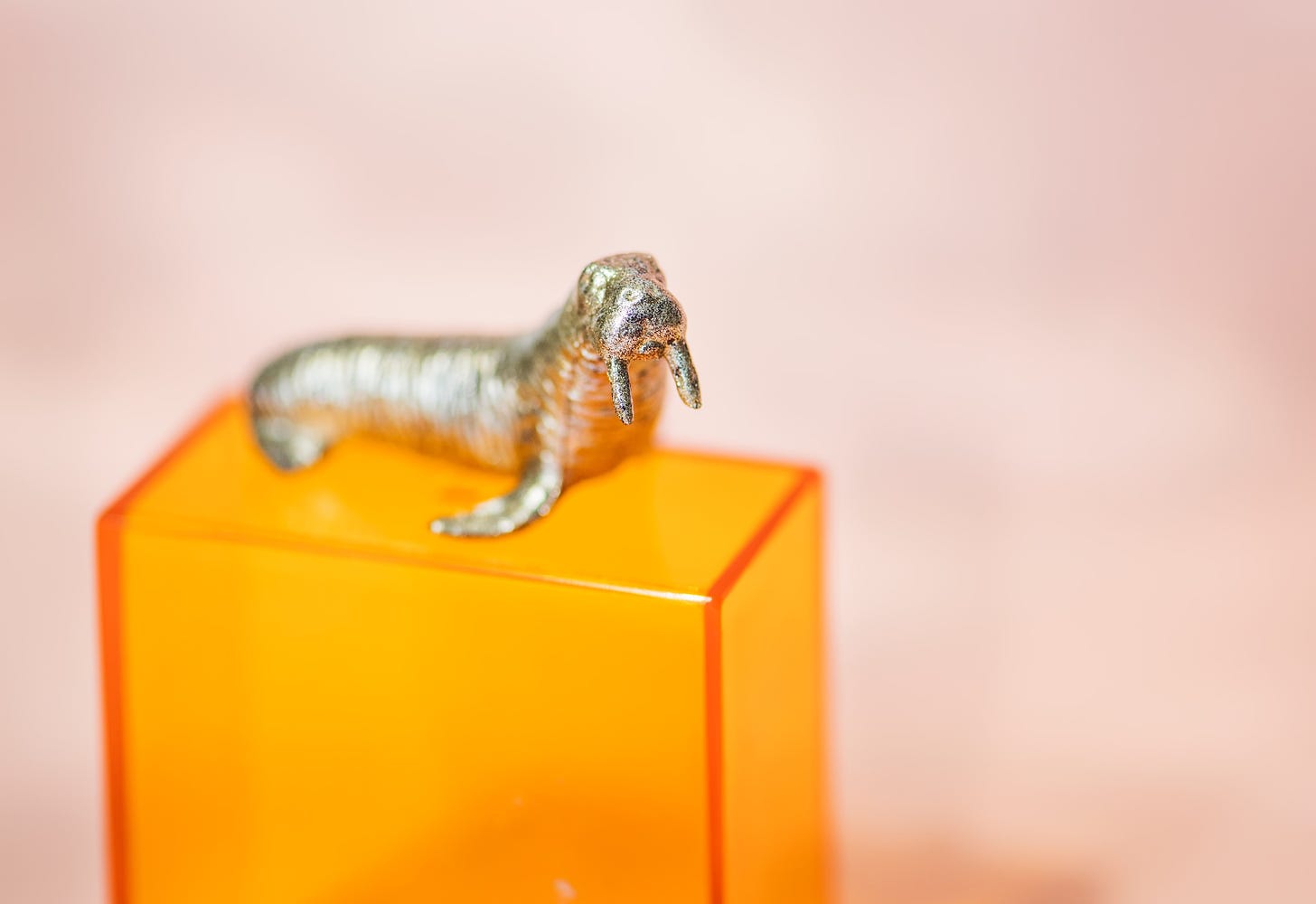 Lone metalic walrus figure sits on block platform