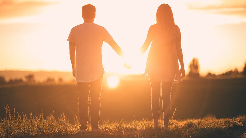 Two lovers in silhouette looking into the sunset