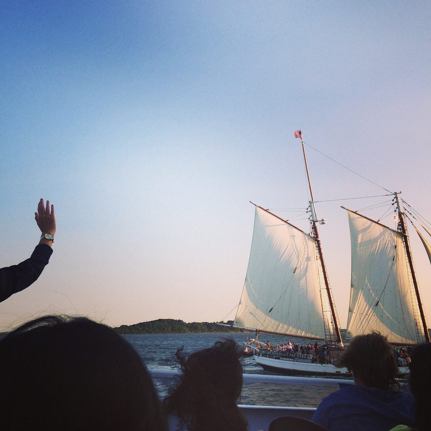 A person waving just out of frame at a large tall ship