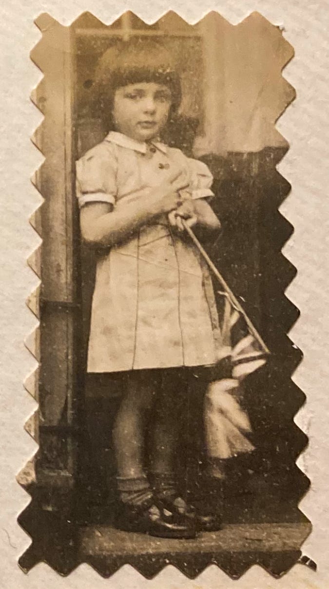 Sepia photo of a young girl wearing a dress and patent leather shoes.