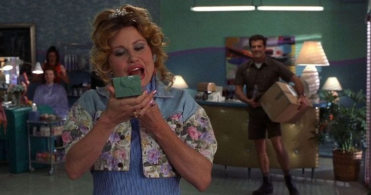 This may contain: a woman holding a piece of chocolate in her hands while standing next to other people