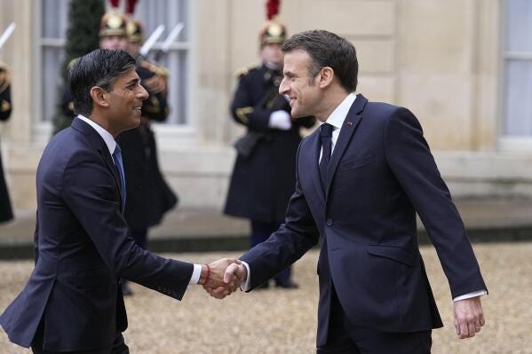 French President Emmanuel Macron, right, shares hands with Britain's Prime Minister Rishi Sunak Friday, March 10, 2023 at the Elysee Palace in Paris. French President Emmanuel Macron and British Prime Minister Rishi Sunak meet for a summit aimed at mending relations following post-Brexit tensions, as well as improving military and business ties and toughening efforts against Channel migrant crossings. (AP Photo/Michel Euler)